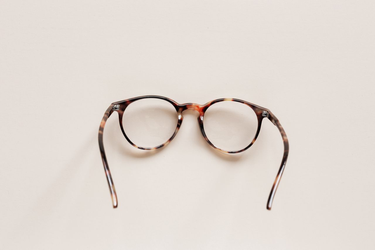 From above of fashion spectacles for vision of round shape in tortoise shell placed on white tabletop